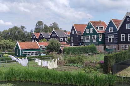 Paisatge autòcton a l'illa de Marken, a Holanda. Contrast de colors foscos de les façanes amb la roba blanca estesa.
