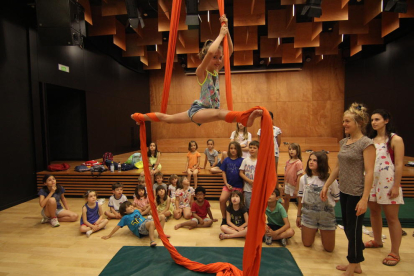Una nena fa uns exercicis acrobàtics en unes teles penjades del sostre de l’Espai Orfeó.