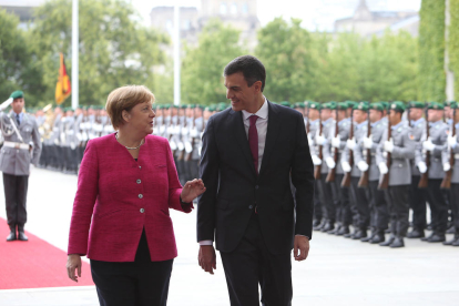 Angela Merkel y Pedro Sánchez conversan tras pasar revista a las tropas.