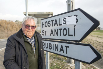 Ramon Tous, que insta l’ajuntament a canviar el nom d’‘Hostalets’ per ‘els Hostals’, davant d’un senyal ‘corregit’ amb un adhesiu.