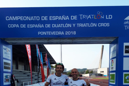 Pere Porta i Àngel Vidal posen sota la pancarta de meta.