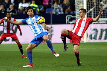 El centrecampista del Girona Pere Pons lluita una pilota amb el davanter Adrián durant el partit.