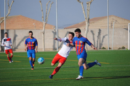 Un jugador del Térmens controla la pilota davant la presència de diversos defenses locals durant una acció del partit.