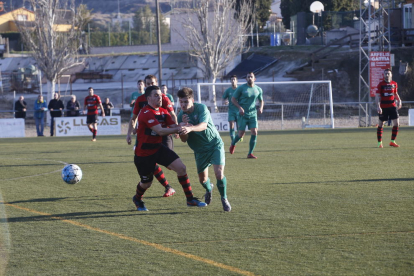 Un jugador del EFAC Almacelles pugna con uno del Martinenc, con varios jugadores de ambos equipos al fondo.