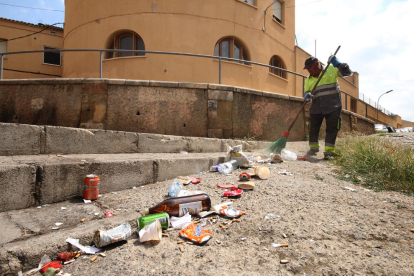Imagen de archivo de tareas de limpieza en la calle Sant Andreu de Lleida llena de botellas y latas de bebidas. 