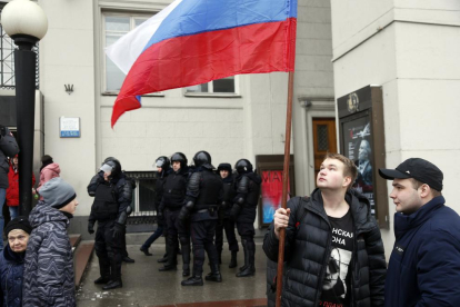 Opositores rusos vigilados de cerca por la policía moscovita.