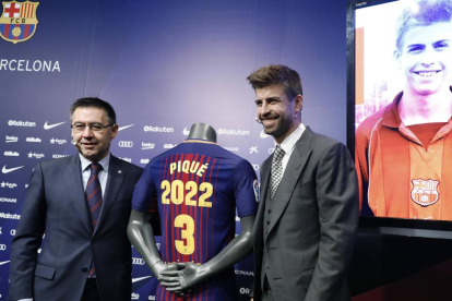 Bartomeu y Gerard Piqué flanquean la camiseta que explicita la renovación del central hasta 2022.