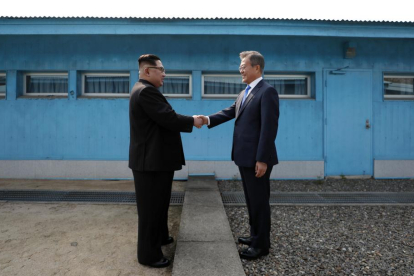 Kim Jong-un i Moon Jae-in es donen la mà a la línia de demarcació militar (MDL) entre els dos països.