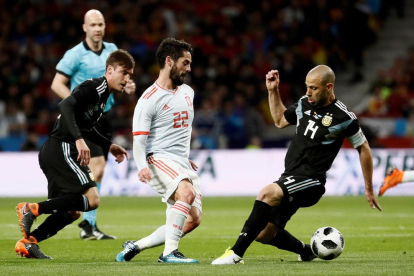 Isco, autor de un ‘hat trick’, supera al exazulgrana Mascherano ayer en el amistoso entre España y Argentina. 