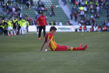 Juanto Ortuño reclama amb un gest obrint els braços entre un núvol de jugadors dels dos equips.