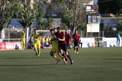 Un jugador del EFAC Almacelles y uno del Balaguer intentan controlar un balón dividido.