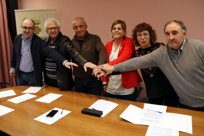 Alcaldes del entorno de Mont-rebei y las presidentas de los consejos de la Noguera y la Ribagorça encajando las manos después de firmar el convenio de colaboración.