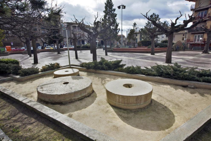 Tres rodes de molí a la plaça com a monument a l’aigua.