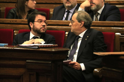 El president del Govern, Quim Torra, parlant amb el vicepresident, Pere Aragonès, en un ple al Parlament.