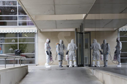 Operarios de una empresa de desinfección entran en la residencia Hogar de Sant Josep de Lleida.