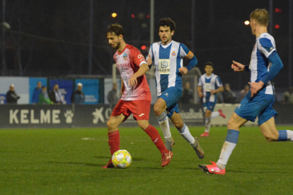 Cano conduce el balón ante la oposición de dos jugadores del Espanyol B.