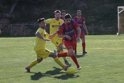 Un jugador del Vilanova de la Barca intenta controlar la pilota davant d’un defensa de l’Alcoletge.