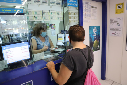 Una clienta comprando lotería en la Rosa de Ponent de Lleida. 