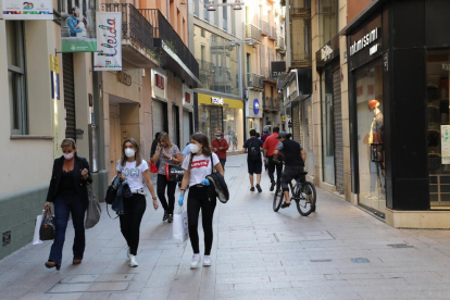 Tres dones passejant ahir a la tarda per l’Eix Comercial de Lleida carregades amb bosses.