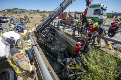 Diez dotaciones de bomberos trabajan para excarcelar el conductor de un camión que ha caído al canal de Balaguer en Alcoletge