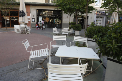 Part de la terrassa d’un local de restauració de Lleida, amb cadires i taules desplegades al carrer.