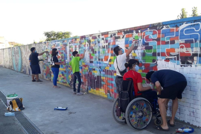 Alguns dels usuaris de Down Lleida, treballant en l’elaboració del mural.