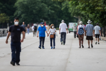 Varias personas paseaban ayer por el parque de El Retiro de Madrid protegidos con mascarillas.