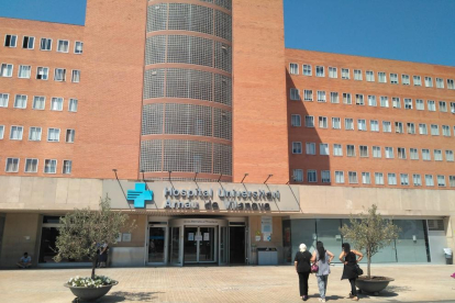 Tres personas dirigiéndose ayer al hospital Arnau de Vilanova de Lleida.