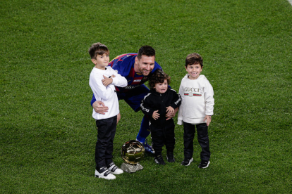Leo Messi posa junto a sus tres hijos en el césped del Camp Nou tras ofrecer el sexto Balón de Oro de su carrera a la afición.