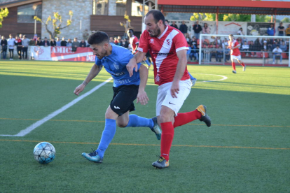 Un jugador de l’Alcarràs condueix la pilota davant la pressió d’un rival.