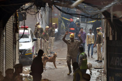 La fábrica incendiada está situada en un callejón de un barrio antiguo de Nueva Delhi. En la imagen, efectivos de salvamento, ayer.