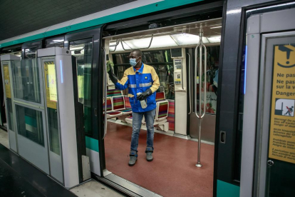 Un operari porta a terme tasques de desinfecció en un vagó de metro a França.