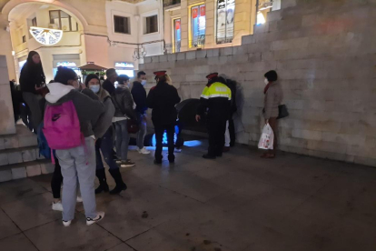 El jove estès a terra, al costat de mossos i a ciutadans que van alertar del succés.