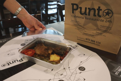 Un restaurant de Lleida preparant un envàs amb menjar sobrant per a un dels clients.