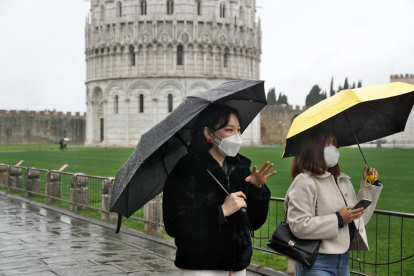 Turistes amb màscara passejant pels voltants de la torre de Pisa.