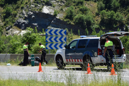 Agentes de los Mossos junto a la moto accidentada ayer en la N-260 en El Pont de Bar. 