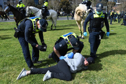 Agentes australianos arrestan a una persona en Melbourne, ayer.