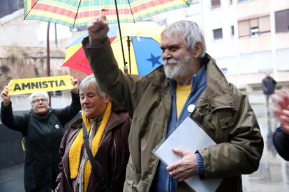 El padre de Oriol Junqueras levanta el puño antes de entrar en los Juzgados de Manresa y acompañado por un grupo de gente que han venido a darle apoyo.