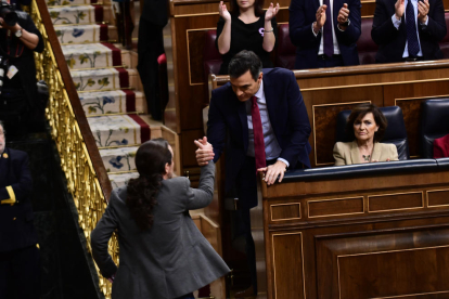Pedro Sánchez i Pablo Iglesias es donen la mà durant el debat d'investidura.