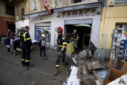 Los bomberos franceses trabajan en la limpieza y despeje de calles y tiendas tras las inundaciones.