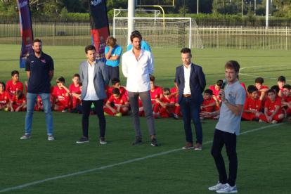 Jordi Aguilar, micrófono en mano, se dirige a jugadores y técnicos durante una actividad de la escuela.