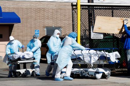 Personal sanitari traslladen morts per coronavirus a una morgue improvisada a Nova York.