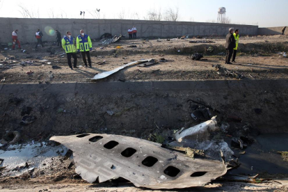 Miembros de los servicios de emergencia observan parte del fuselahe del Boeing 737 de la compañía ucraniana UIA que se estrelló en la madrugada del miércoles en Teherán