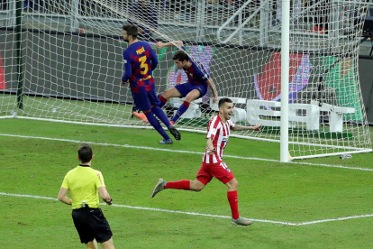 Messi, que volvió a hacer un gran partido, intenta irse del marcaje de los rojiblancos Saúl y Thomas.