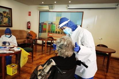 Sanitarios extraen la muestra para la PCR a una usuaria de la residencia Sant Domènec de Balaguer.