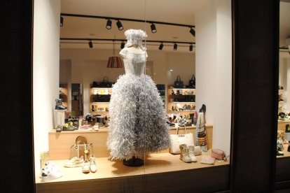 Una tienda del centro, con un vestido de papel en su escaparate. 