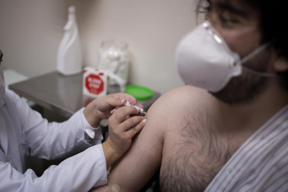 Un sanitario inyecta en un voluntario una candidata a vacuna contra el coronavirus.