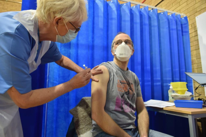 David Farrell, paciente de 51 años, recibe una de las dos vacunas de Pfizer y BioNtech en un centro de vacunación en Cardiff (Reino Unido).