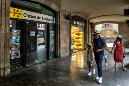 Una familia ante una oficina de turismo cerrada en la ciudad de Barcelona.