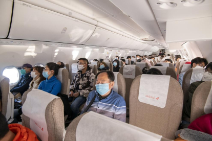 Pasajeros de un vuelo regional chino, todos con mascarillas.